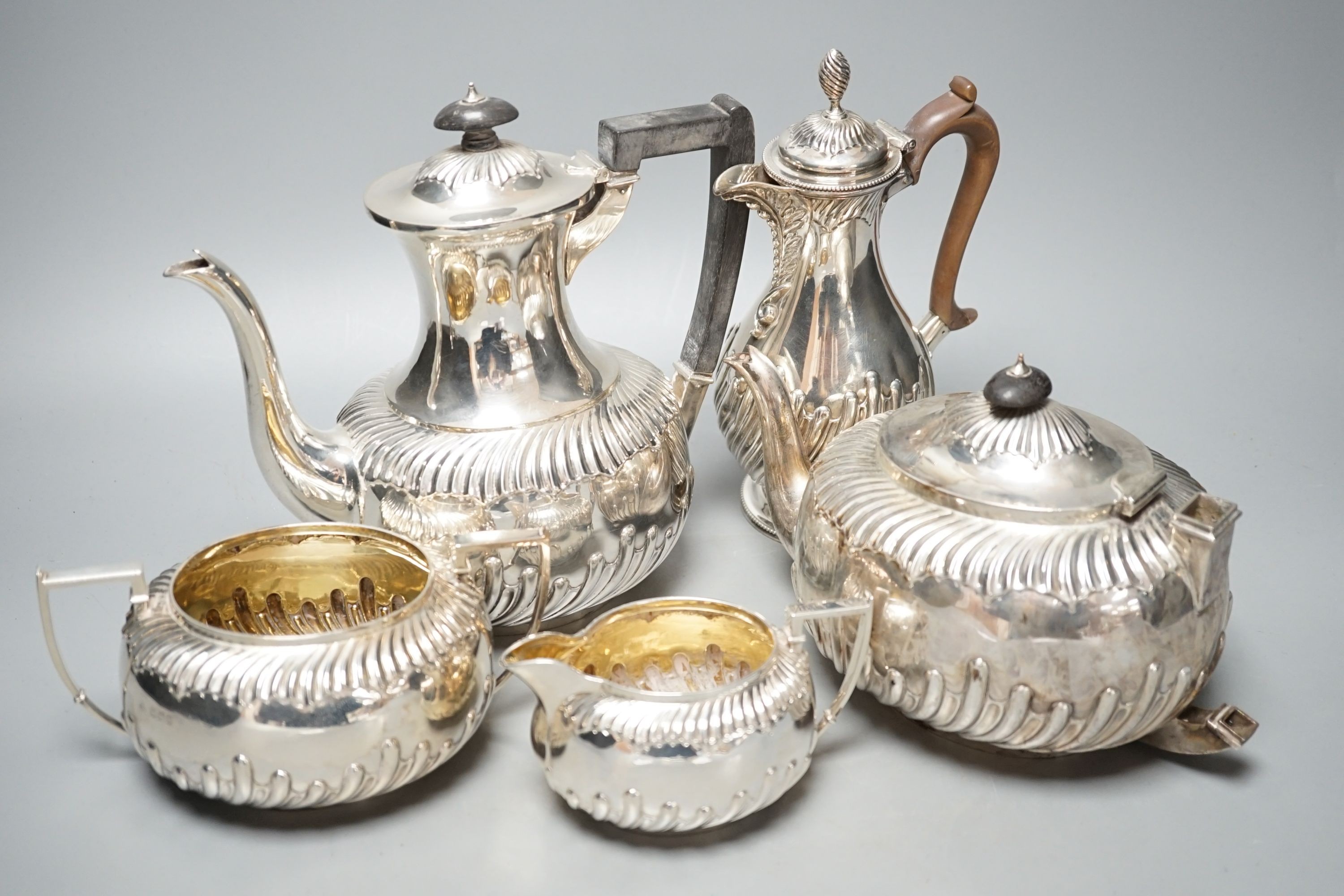 A late Victorian repousse silver four piece tea set, Martin, Hall & Co, Sheffield, 1892, (a.f.) together with a Victorian silver hot water jug, Charles Stuart Harris, London, 1884, gross 60.5oz.